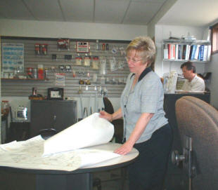 Candace looks over prints for a fire alarm system...